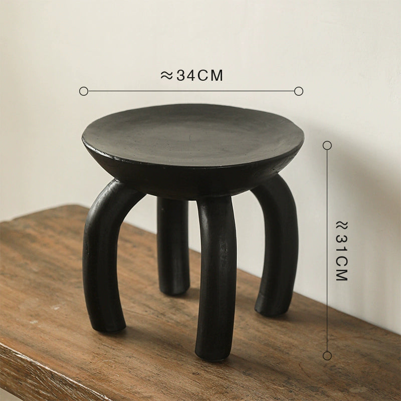Ethnic Style Wooden Side Table - black round coffee table with curved legs on wood surface.