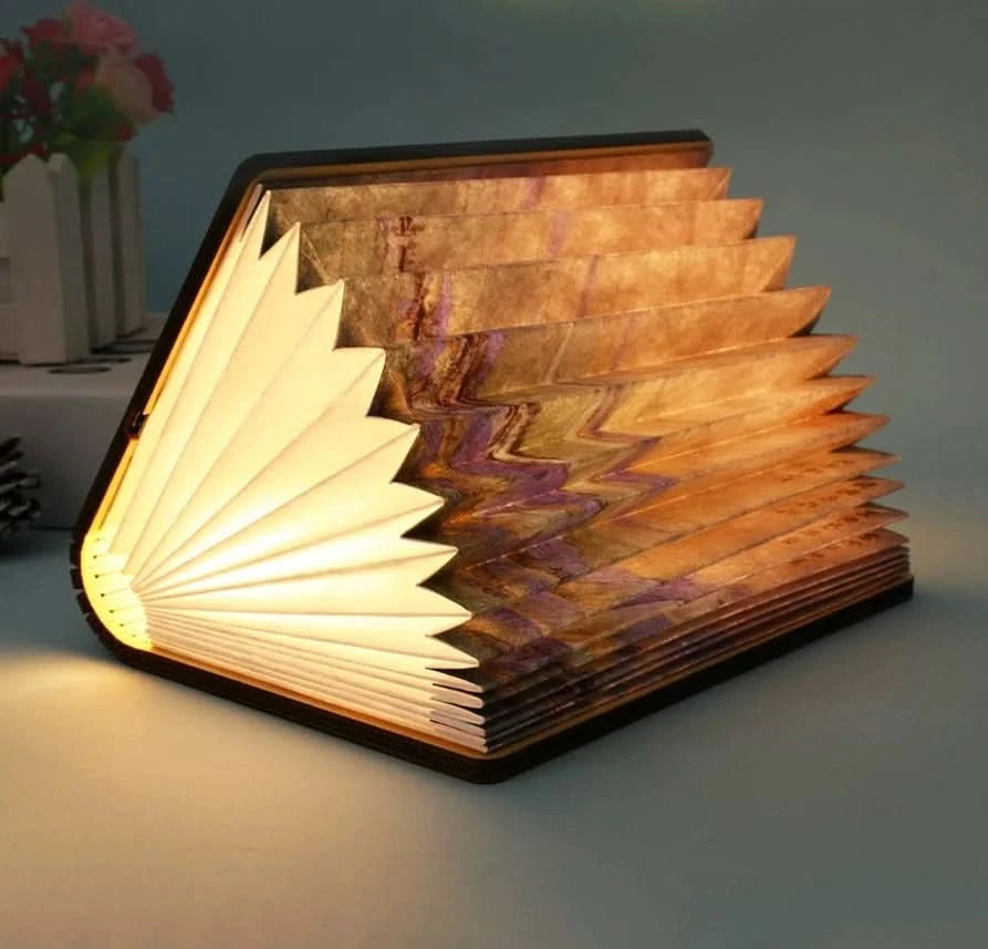 Warm glow from customizable book paper table lamp, featuring illuminated pages & ornate cover.