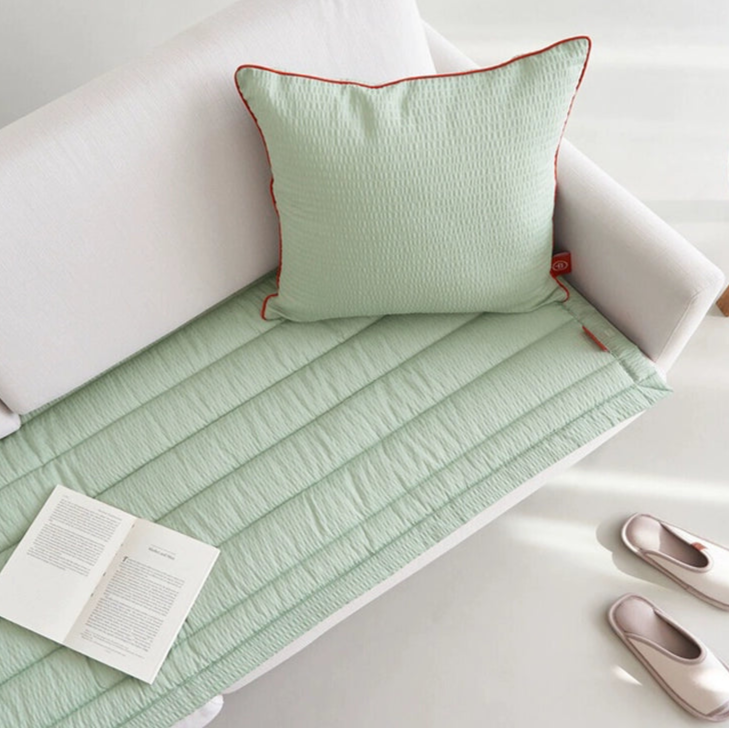 Green Gingham Sofa Protector & Rug Set on white sofa with book and slippers.