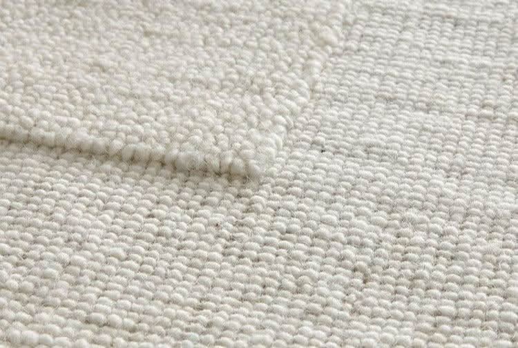 Close-up of Natural Handwoven New Zealand Wool Rug in cream, showing textured weave.