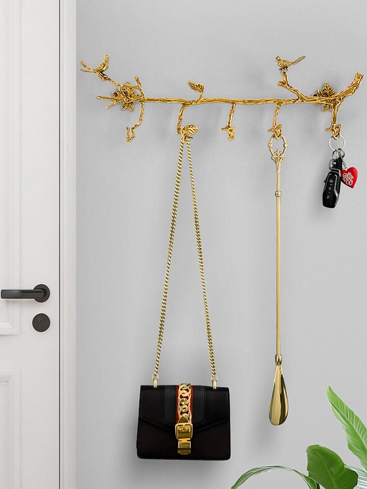 Vintage Brass Bird Branch Wall Hooks holding black purse, keys, and shoe horn on grey wall.