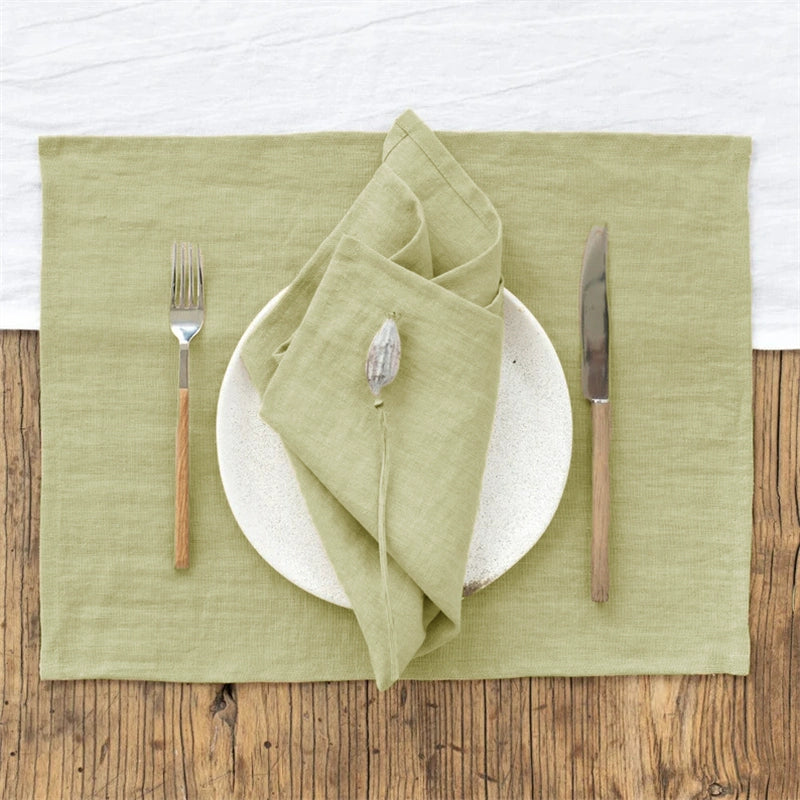 Elegant Linen Table Napkins set a sage green place setting with fork and knife.