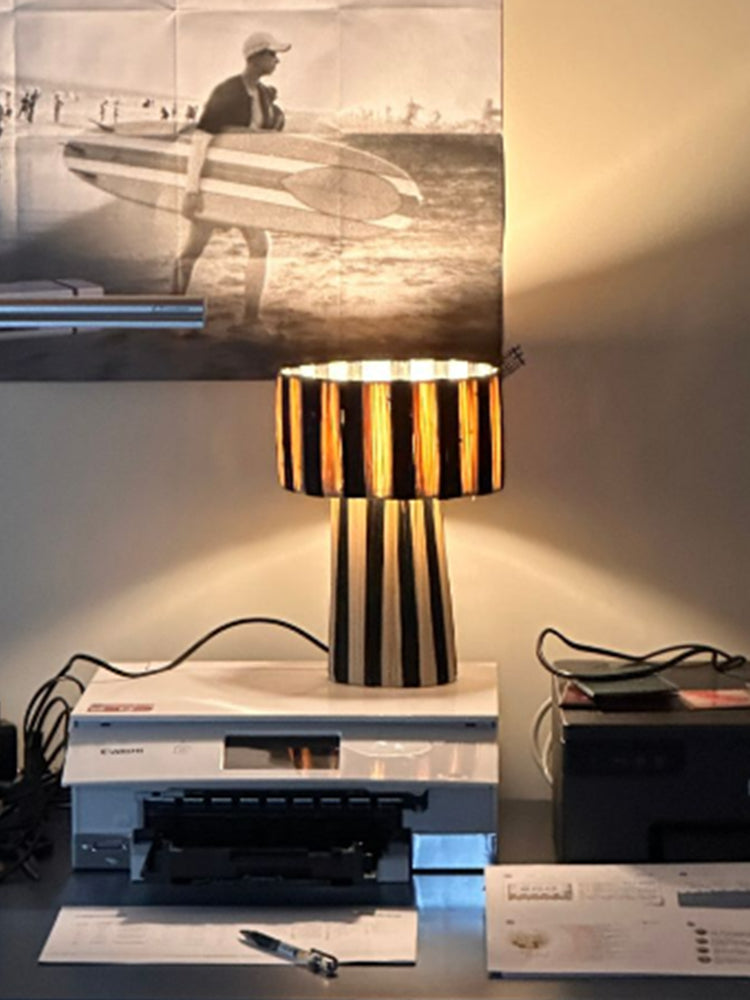 Moroccan Raffia Striped Desk Lamp with natural fiber shade casting warm light.