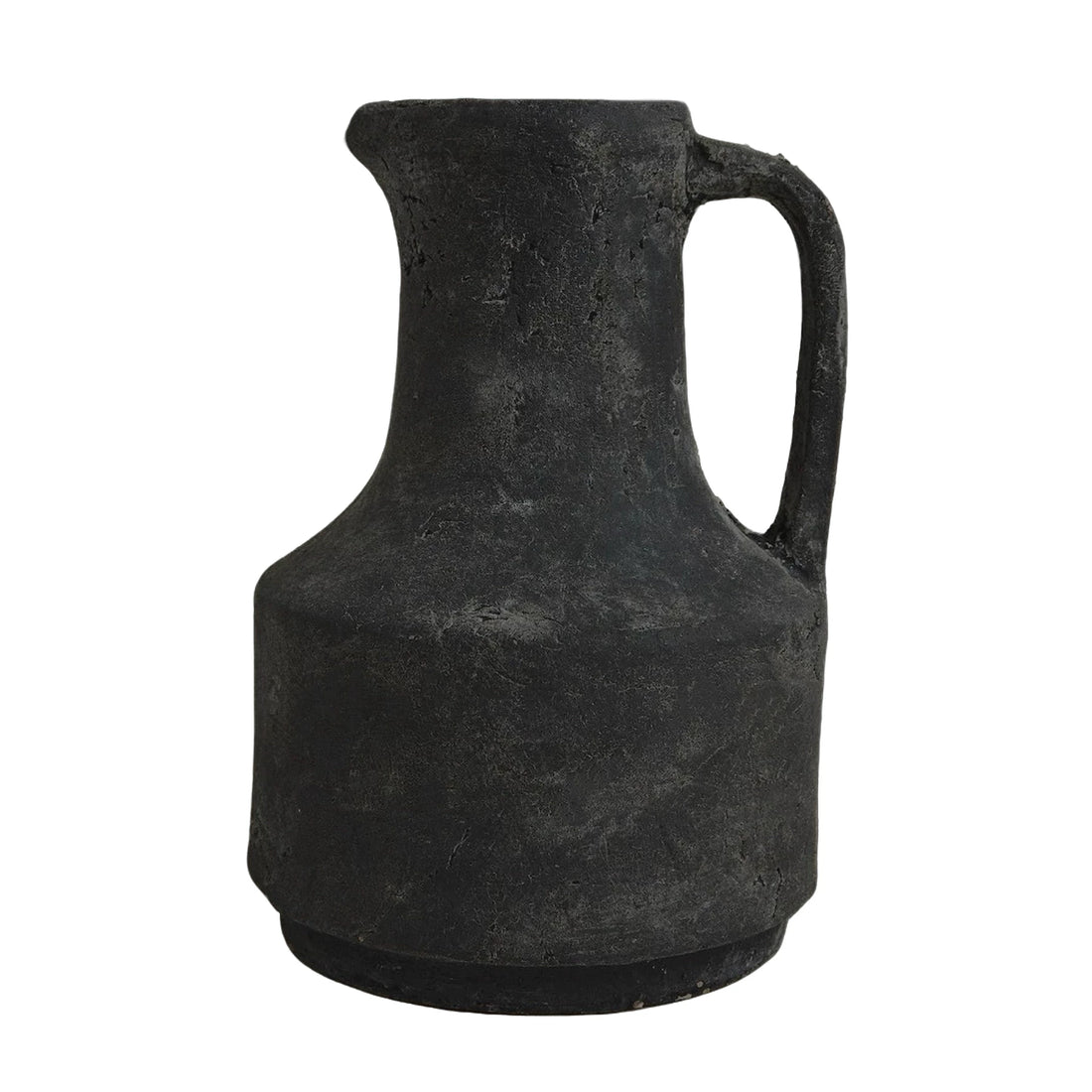 Isolated studio shot of a rustic handmade black ceramic pitcher with a singular handle.