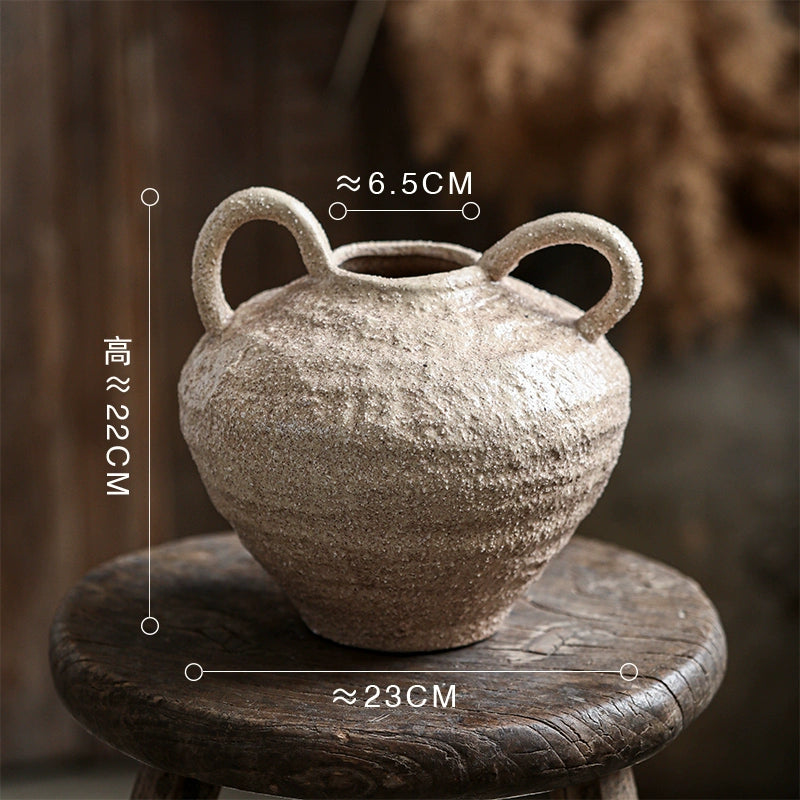 Rustic ceramic vase with handles, handcrafted decorative pottery home decor on rustic stool.