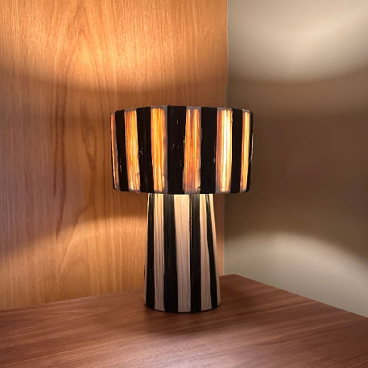 Moroccan Raffia Striped Desk Lamp with natural wood backdrop.