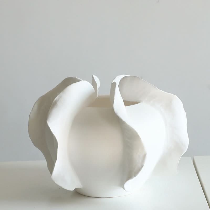 Modern white ruffled ceramic vase with flowing petal design, home decor.