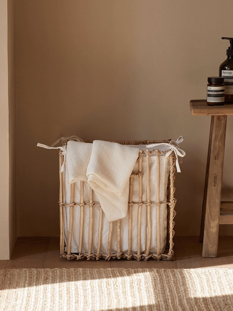 Square woven rattan storage basket with linen lining. Light beige color.  Natural material.  Home decor.