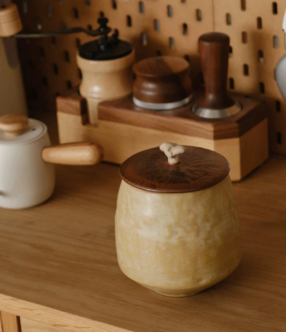 A white ceramic storage jar with a textured curd glaze and a natural wooden lid.