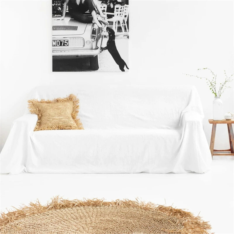 Mustard yellow linen sofa throw blanket draped over white couch with jute pillow.