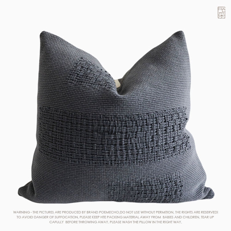 Dark gray woven throw pillow, featuring a unique textured pattern.  Handcrafted design.