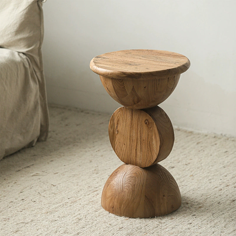 Bohemian wooden side table with stacked round design on cream rug.