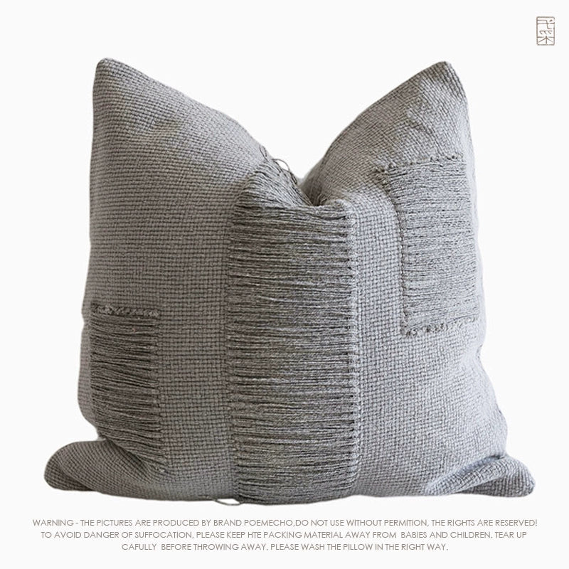 Gray woven throw pillow with textured detail, modern boho decor.