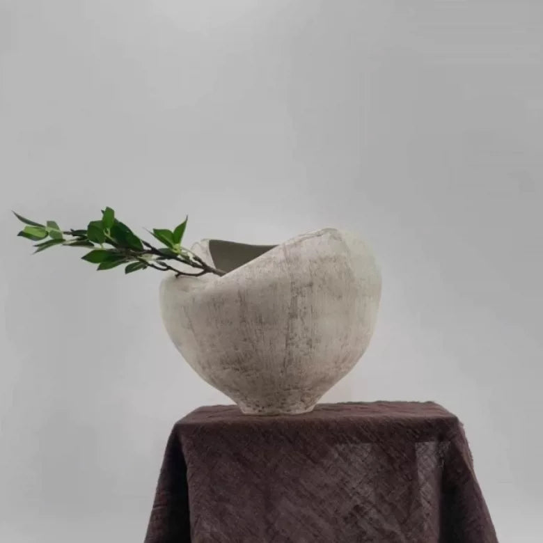 A white handmade ceramic vase with a sculptural, folded organic design.