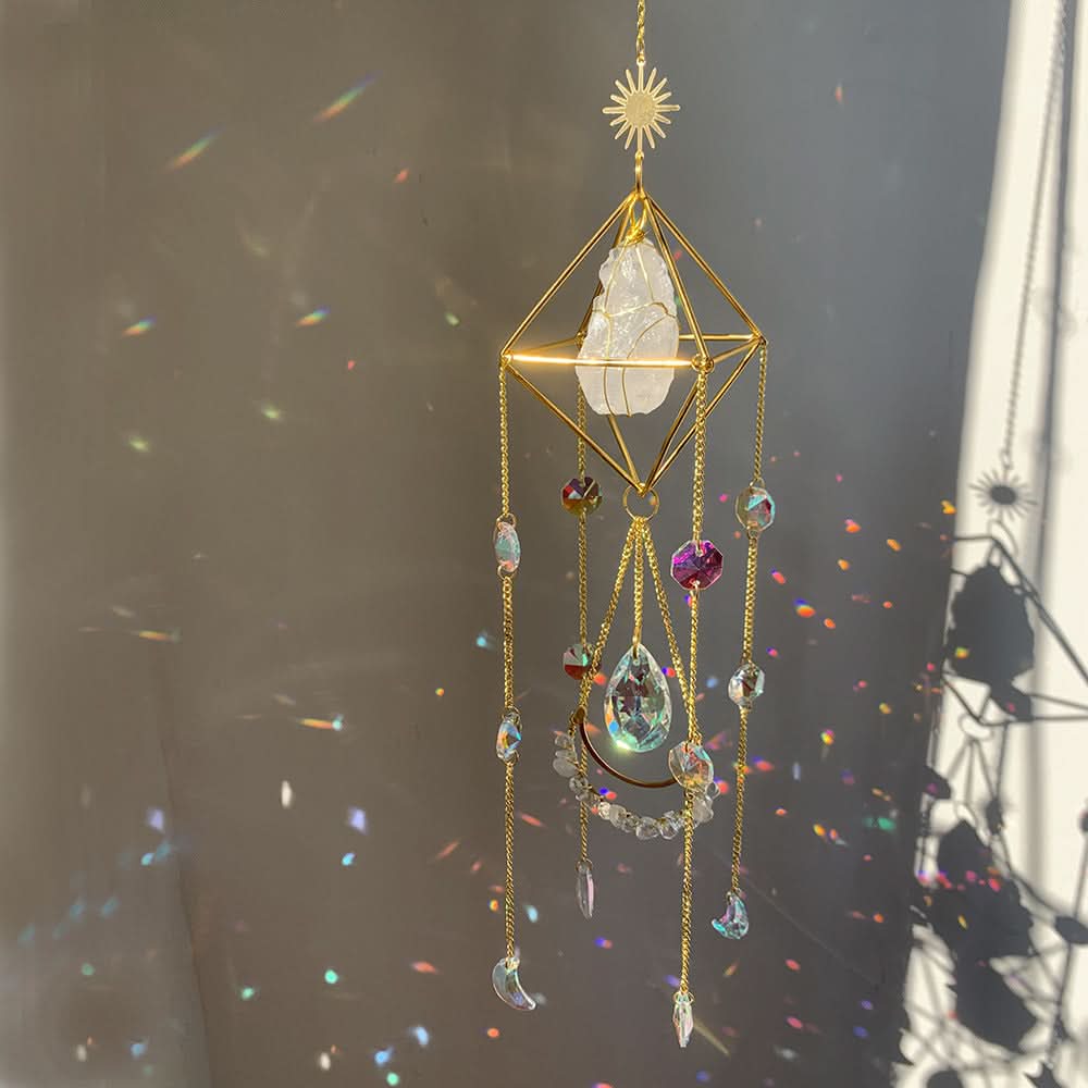 Golden geometric crystal diamond sun catcher with rainbow prisms refracting on a grey wall.