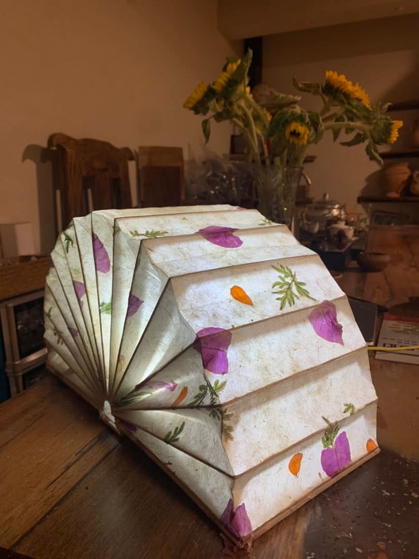 Modern Pleated Fabric Pendant Light with floral accents, on wooden table, home decor.
