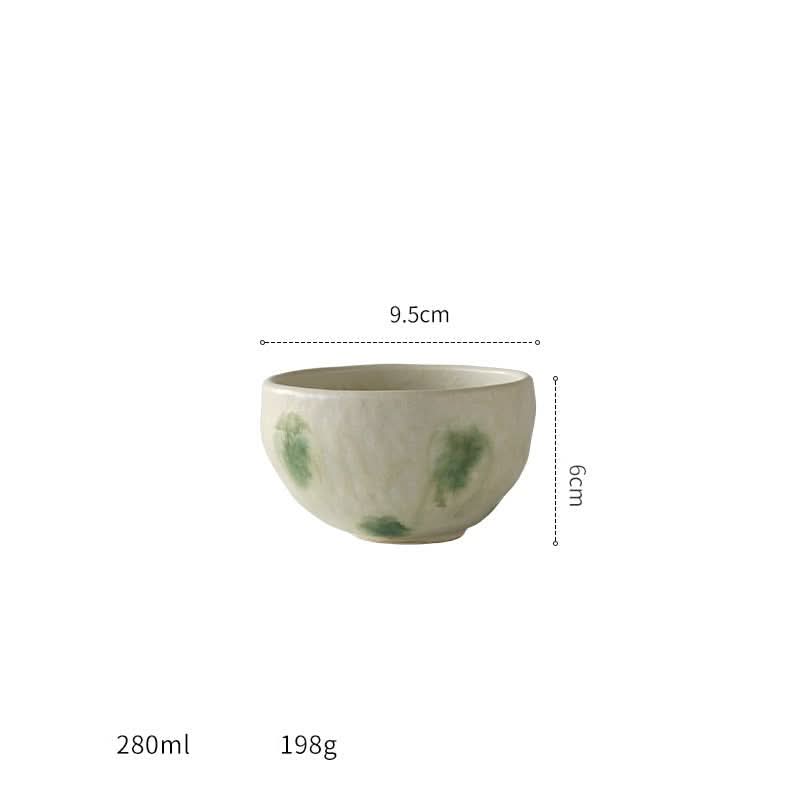 Japanese imported Mino-yaki wedge-shaped matcha bowl in cream with green accents.
