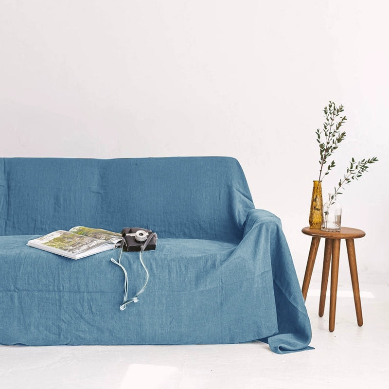 Mustard Yellow Linen Sofa Throw Blanket on blue couch with magazine, camera, and plant.