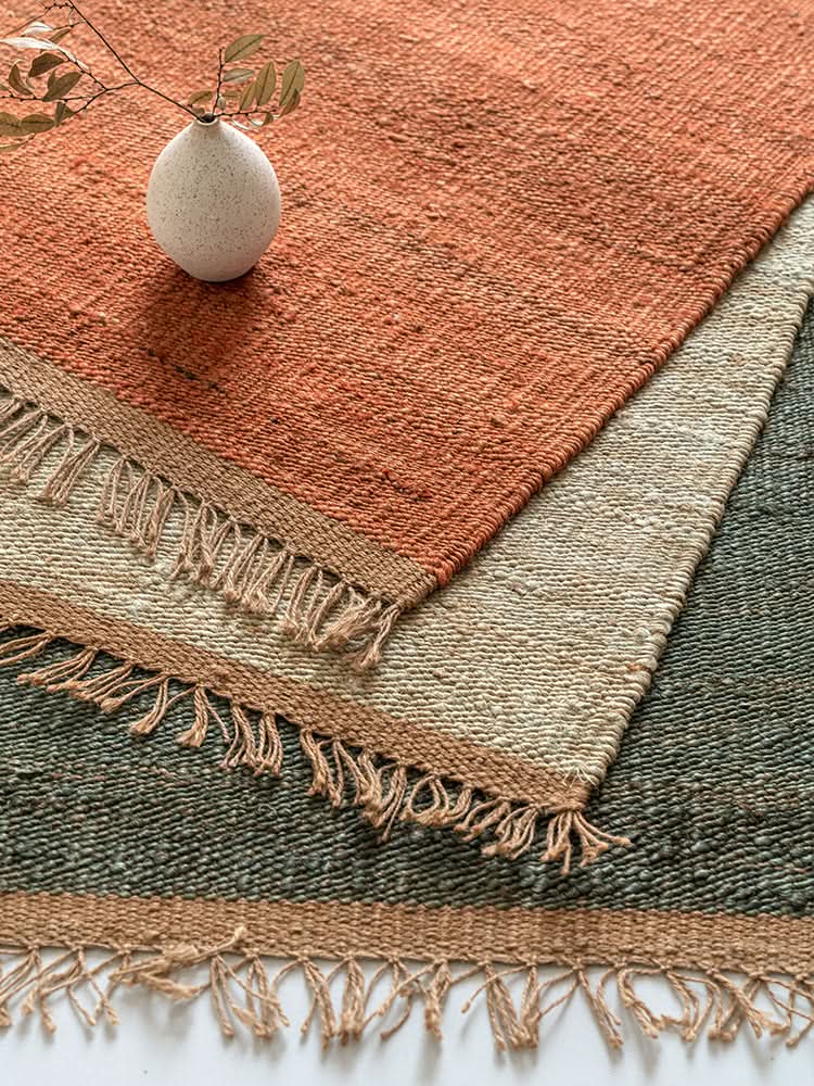Handwoven Jute Rug: Natural jute with rustic stripes of terracotta, beige, and olive green. Fringed edges.
