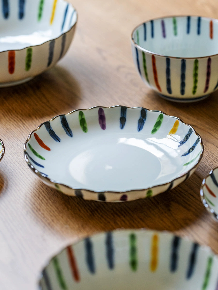 Colorful Striped Japanese Dinnerware Set with ceramic bowls and plates on a wooden table.