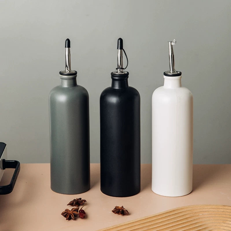 A matte ceramic oil dispenser with a sealed spout, designed for pouring liquids.