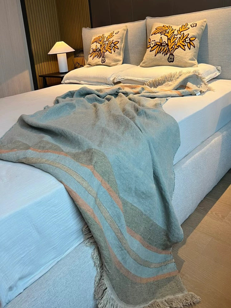 Cozy Striped Linen Throw Blanket in multicolor, draped on a bed with decorative pillows.
