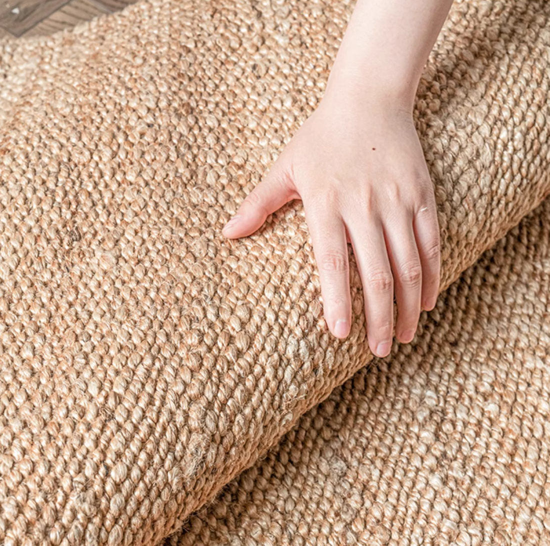 Natural jute scalloped rug in neutral tones, showing texture and hand detail.
