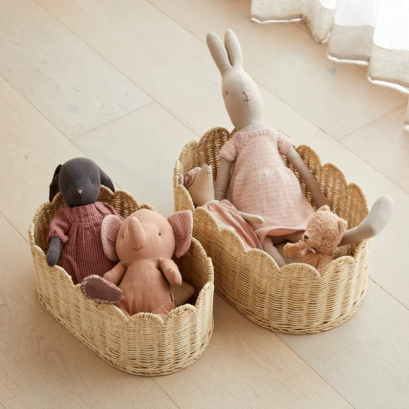 Two natural rattan wicker baskets with scalloped edges.  Light beige color.  Filled with stuffed animals.  Storage.