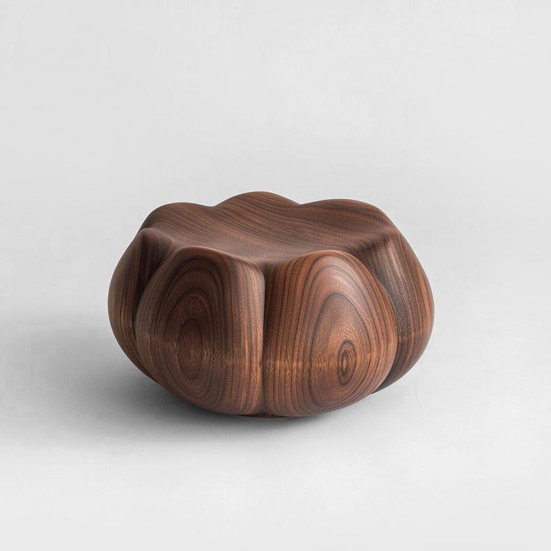 Hand-carved walnut wood pumpkin stool with rich grain, on a light gray background.