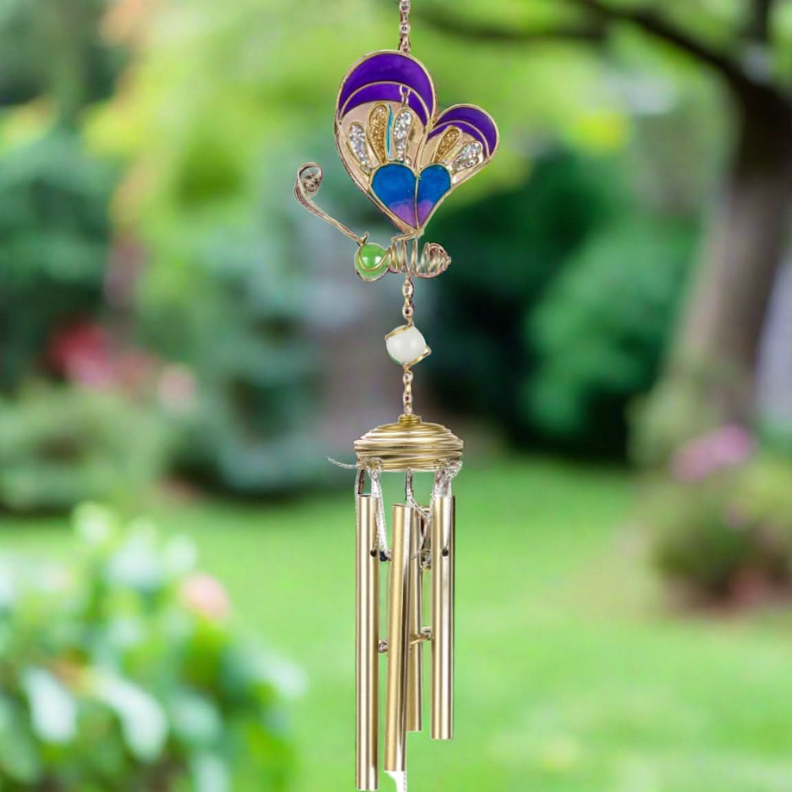 Golden butterfly wind chime with purple and blue accents, outdoors.