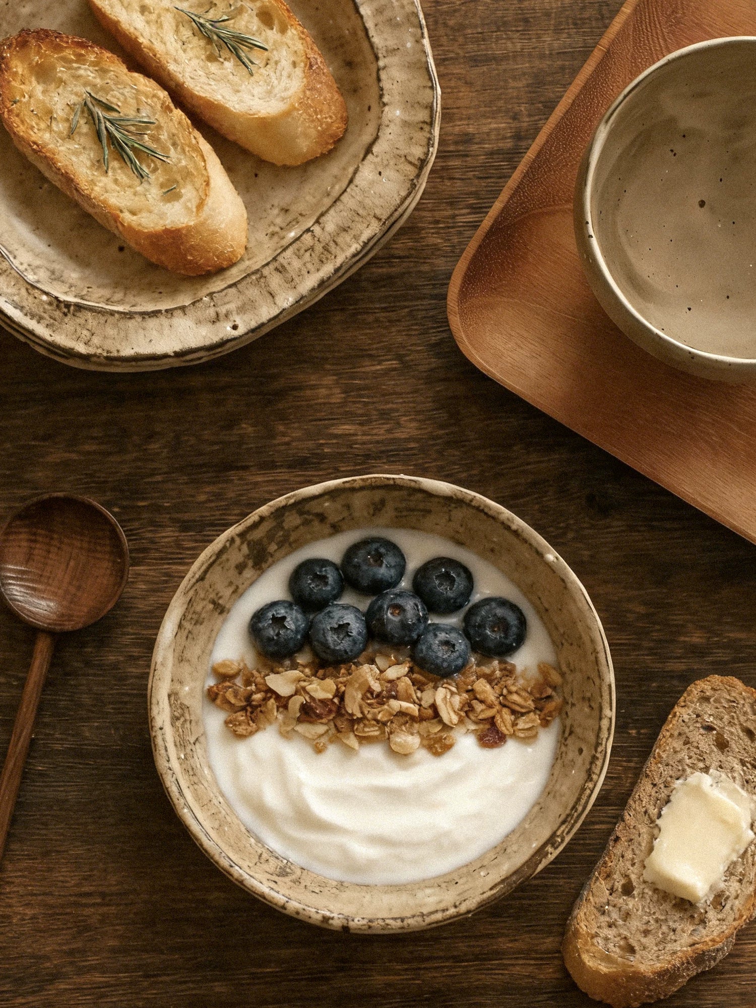 A rustic coarse pottery plate and bowl set with mottled textures and irregular rims on a dark surface.