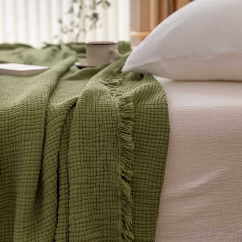 Green Four-Layer Waffle Weave Cotton Throw Blanket with fringe detail, soft and cozy for Spring/Fall.