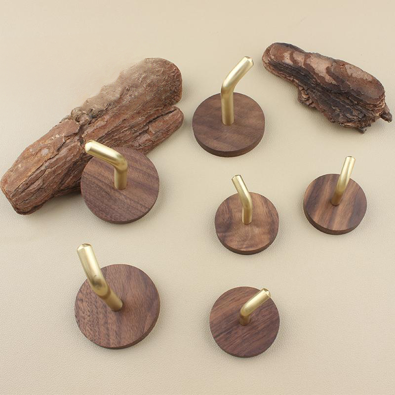 Walnut & Brass Wall Hooks: Set of rustic wood and gold coat hooks on a neutral background.