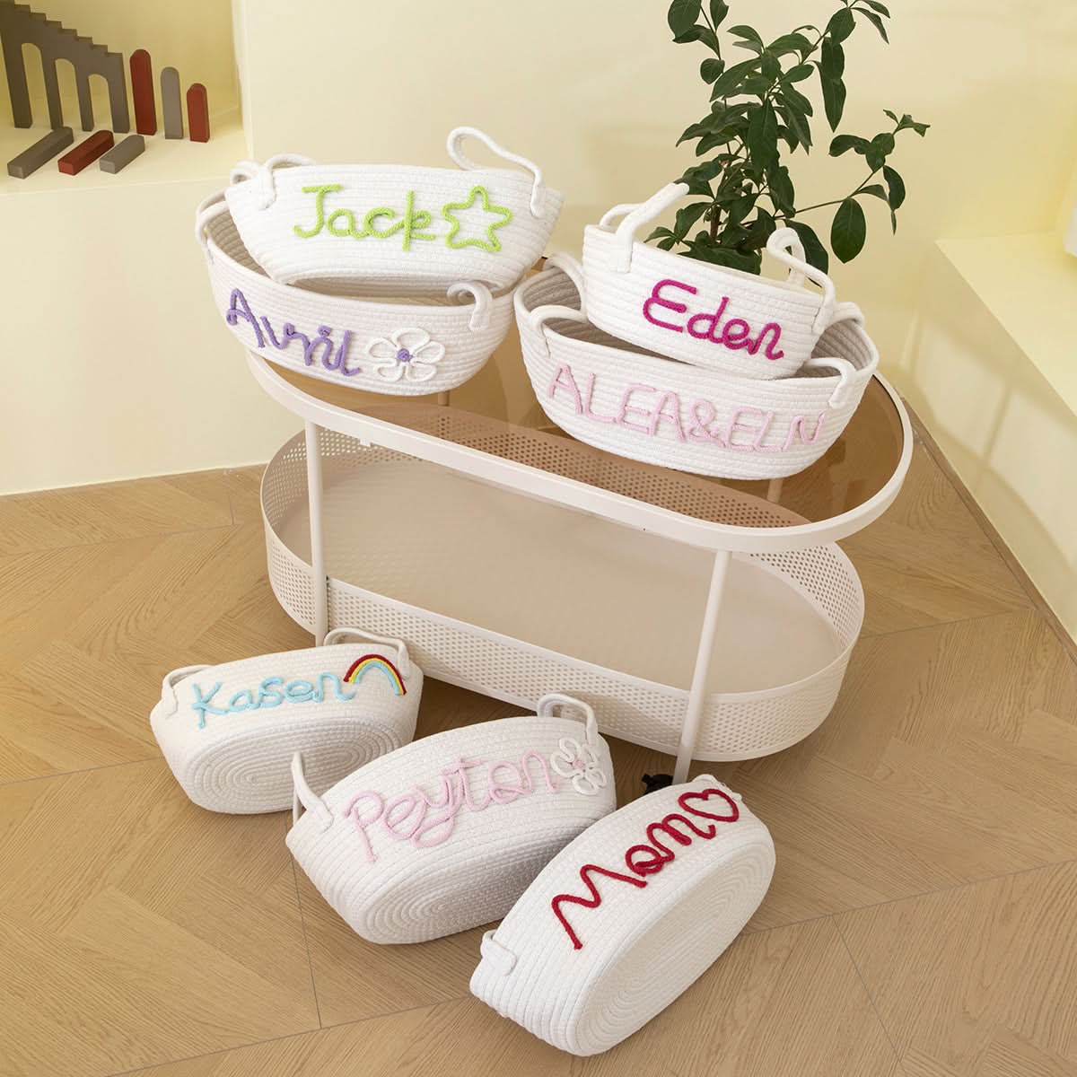 Personalized woven storage baskets with names like Jack, Eden, & Mama displayed on white rope, home decor.