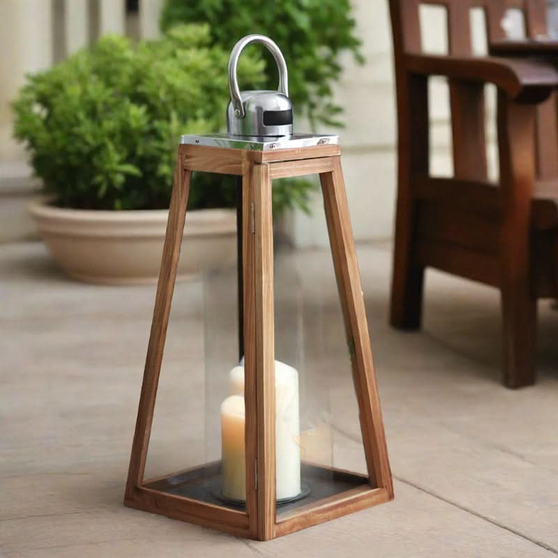 Triangular rustic wooden lantern with glass panels and metal handle, holding lit candles.