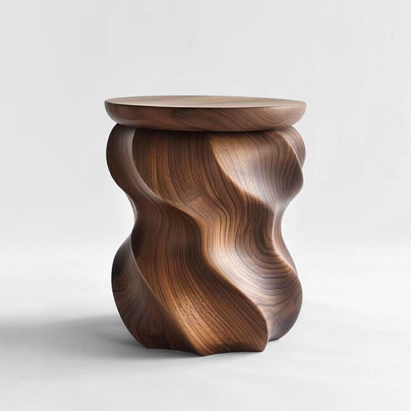 Sculptural walnut wood stool with organic curves on a white background.