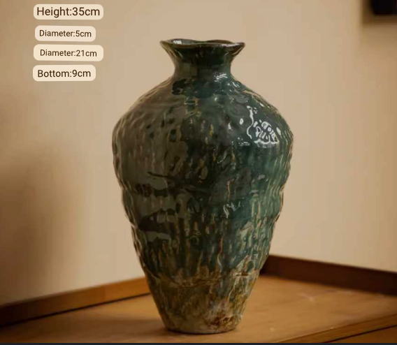 Wabi-Sabi distressed rustic vase with dark green glaze on wooden surface.