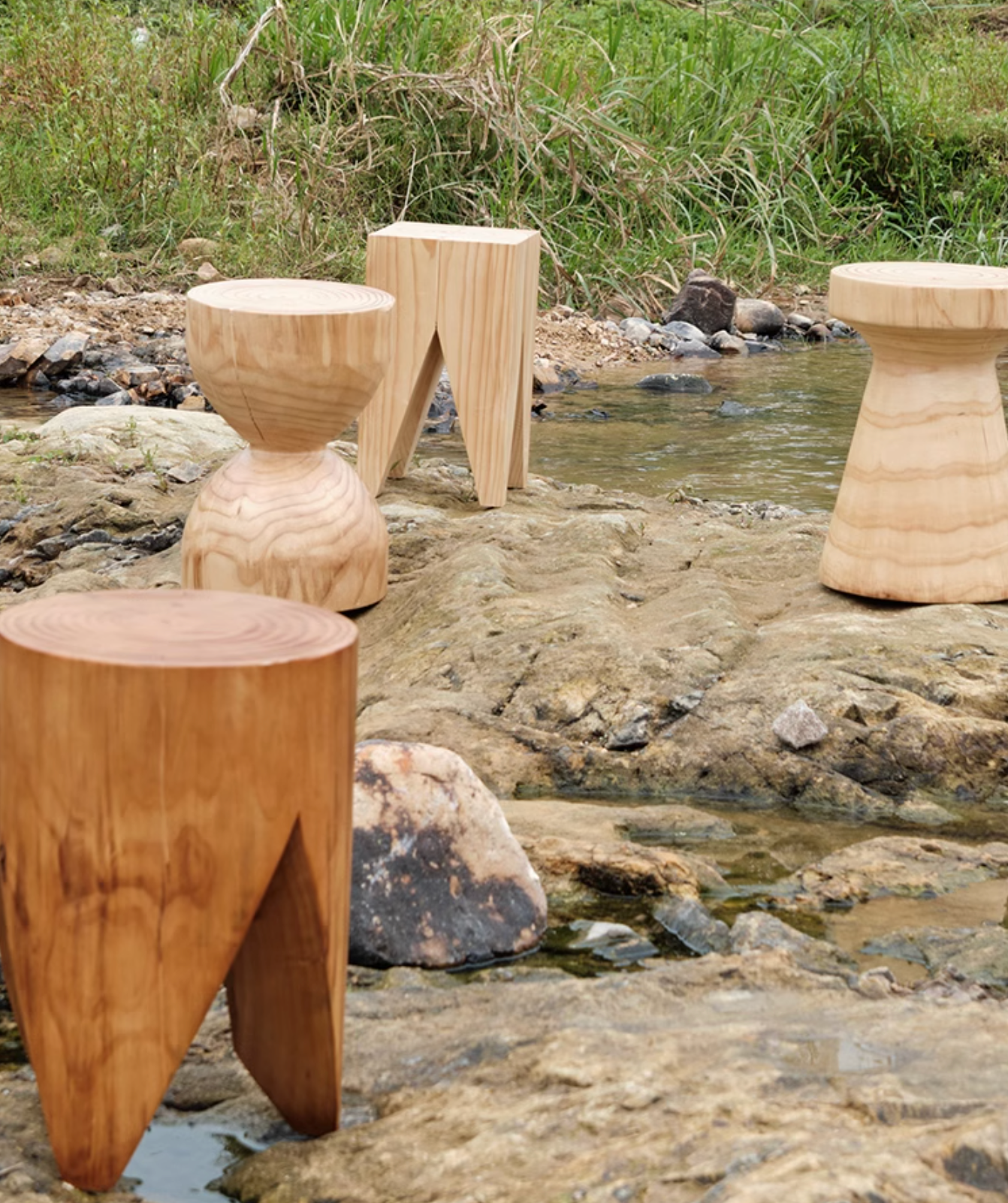 Natural wood stools, customizable size, on rocky creek bed.