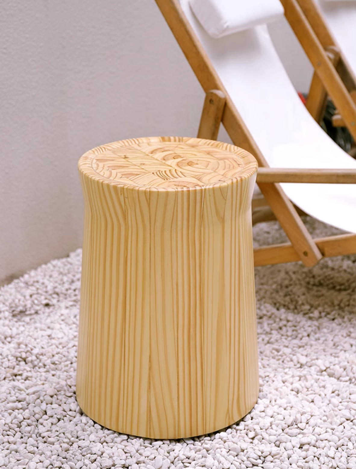 Natural wood stool with customizable size, shown on white pebbles.