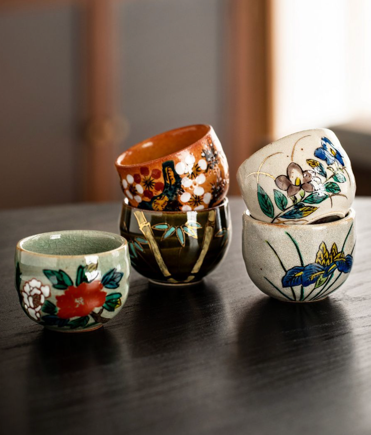 Five-Herb Flower Tea Cup Set 2.03 oz/60ml ceramic cups with floral designs on dark wood.