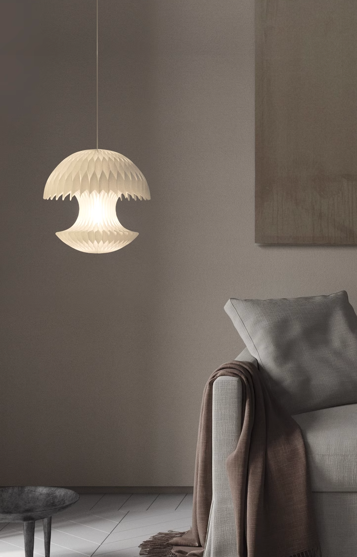 White Geometric Origami Paper Lampshade hanging over a sofa in a modern living room.