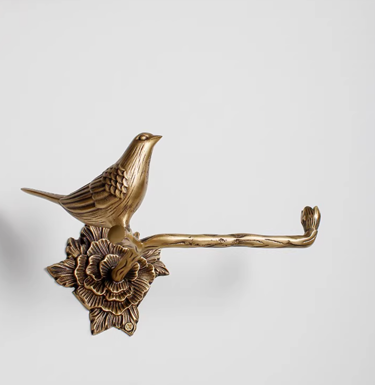 Brass bird toilet paper holder with floral base, elegant bathroom home decor.