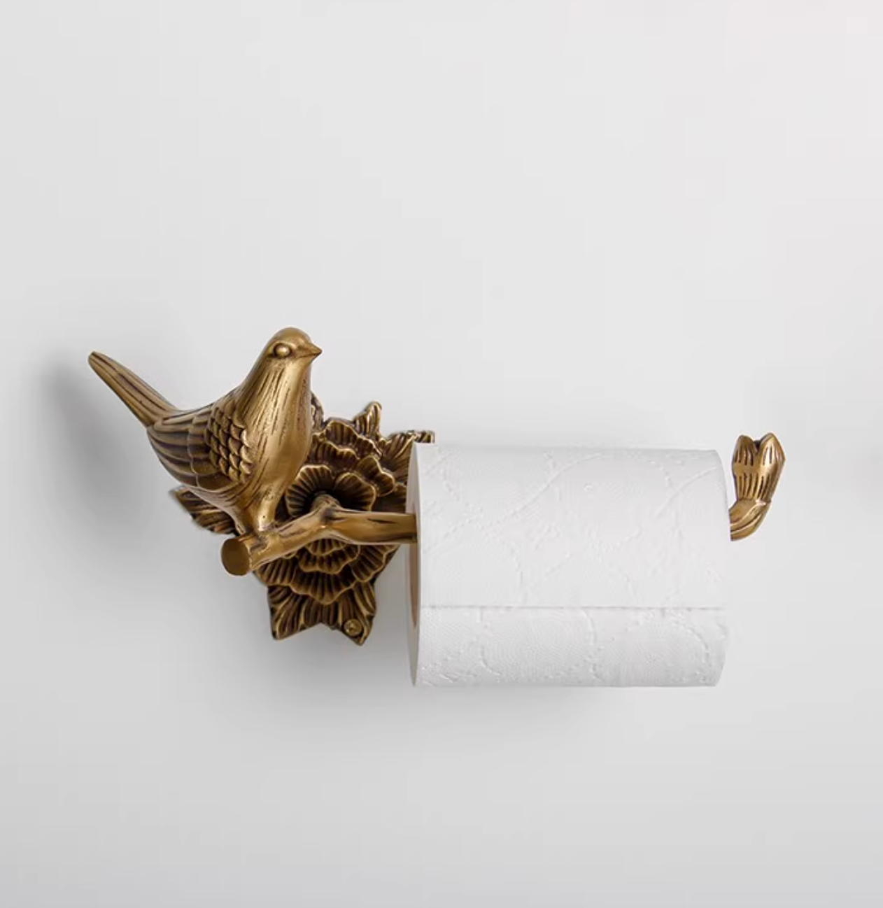 Antique brass bird toilet paper holder, part of a bathroom set.