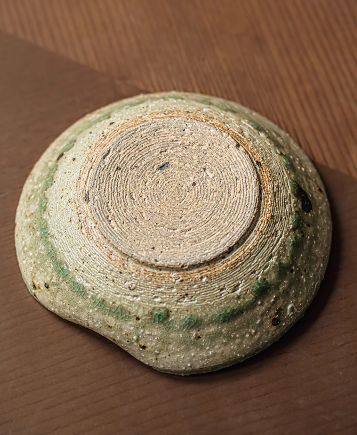 Artisan Green Dinnerware ceramic bowl, textured base with rustic green glaze accents on a wooden surface.