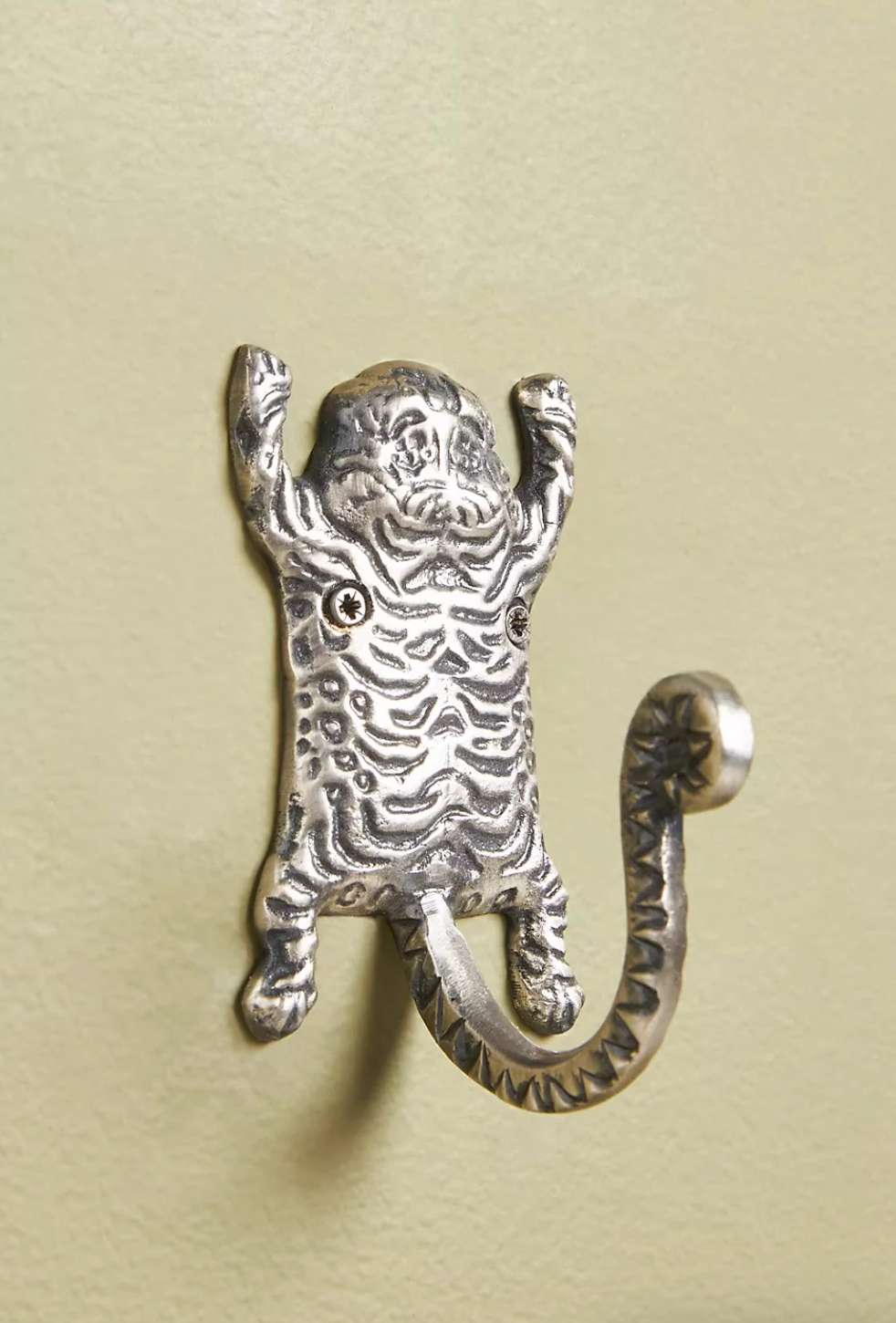Silver tiger hook accessory from the Gold Tiger-Inspired Bathroom Accessories Set, mounted on a pale green wall.