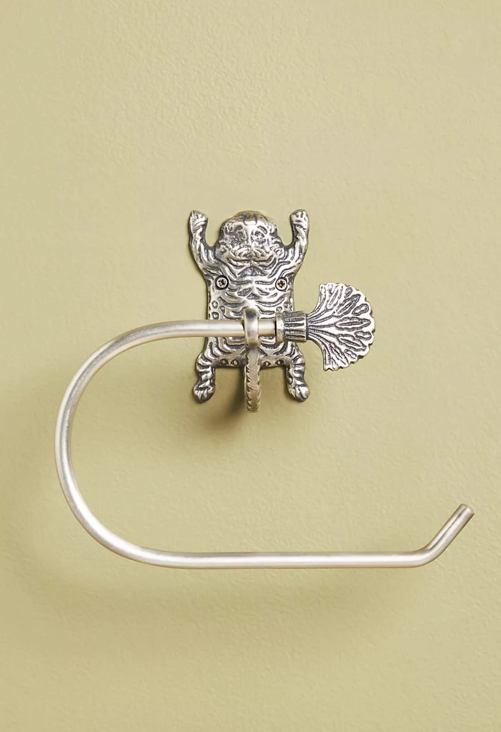 Silver metal Gold Tiger-Inspired Bathroom Accessories toilet paper holder on a pale green wall.
