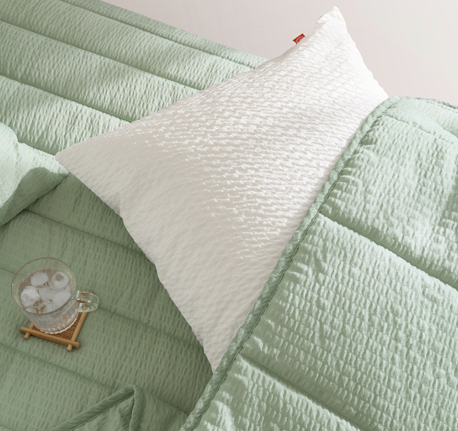 Green Gingham Sofa Protector & Rug Set with white pillow and iced drink. Cozy home decor.