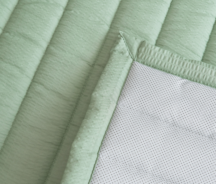 Green Gingham Sofa Protector & Rug Set closeup showing quilted texture and polka dot backing.