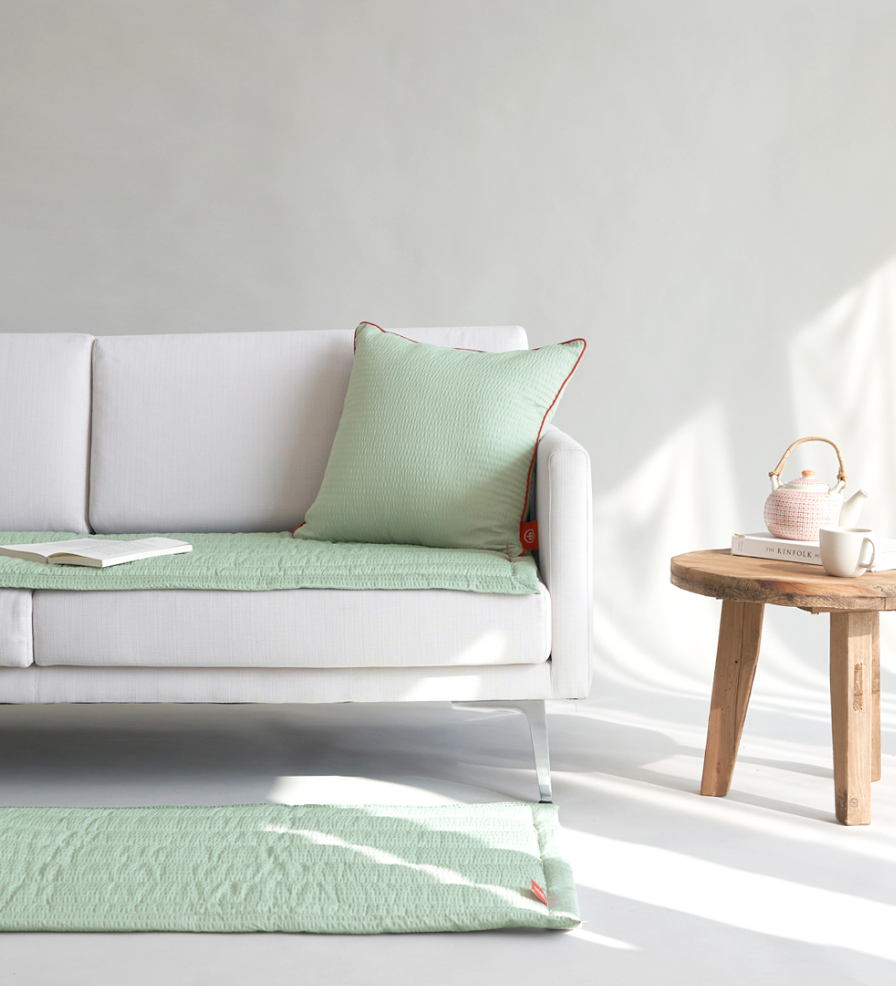 Green Gingham Sofa Protector & Rug Set on white sofa with decorative pillows and side table.