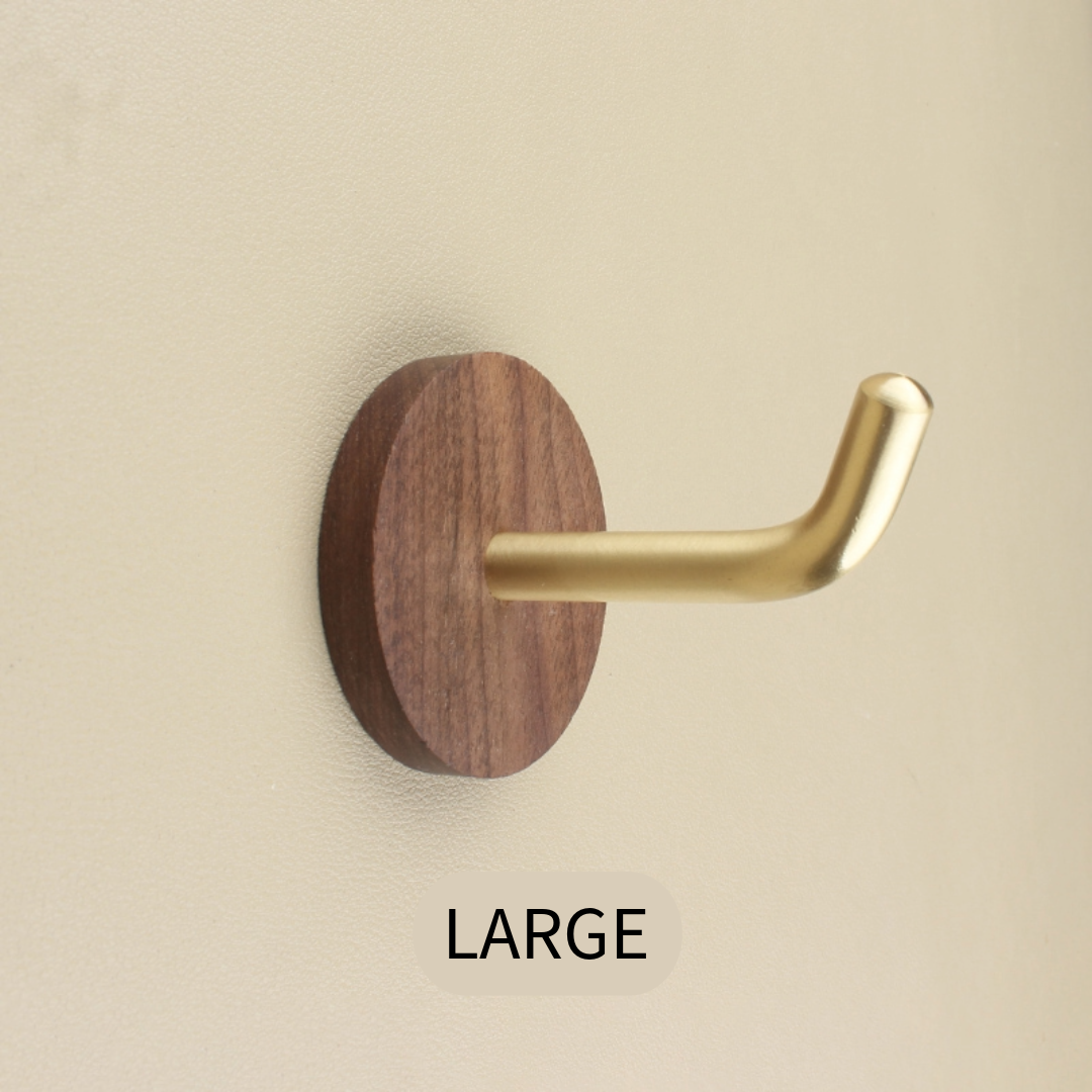 Walnut & Brass Wall Hook, large size, mounted on a light beige wall.